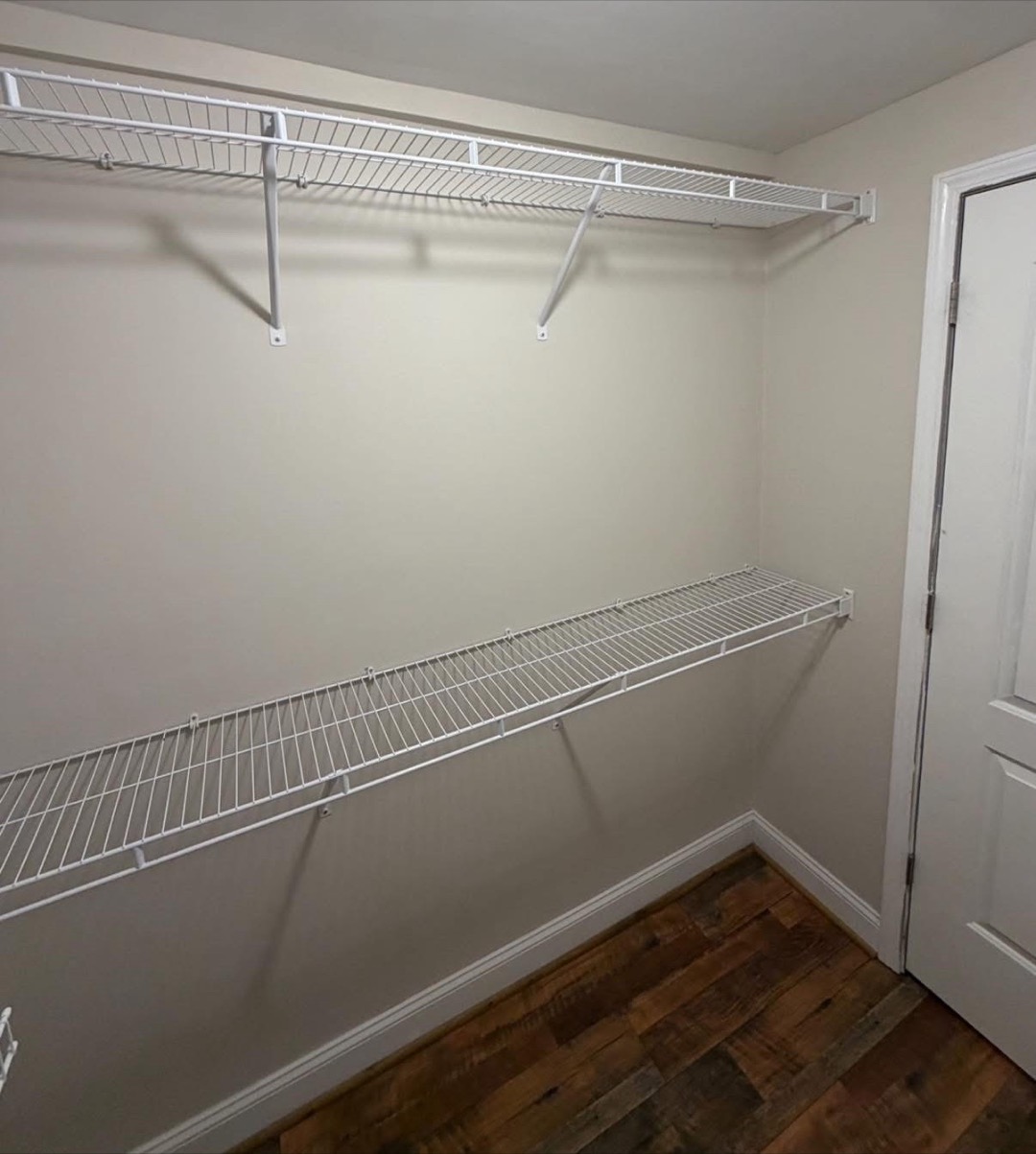 The finished closet: painted walls, new baseboard, wood-look flooring, and two runs of wire shelving.